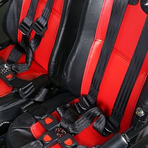 Kinderbuggy GK002B Zweisitzer – Sitze und Sicherheitsgurte Zwei rot-schwarze Sitze mit Mehrpunktgurten und Gurtschlössern im GK002B Kinderbuggy in Nahaufnahme.