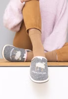 ein Paar graue Filzpantoffeln mit gestickt und appliziertem Schafsmotiv sowie darunter der Schriftzug Unschuldslamm. Außen hell eingefasst und oben mit rosa Karoband sowie Schleifchen