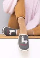 ein Paar dunkelgraue Filzpantoffeln mit süßer Lama-Applikation und darunter pinker Schriftzug "Weltenbummlerin". Außen hell eingefasst