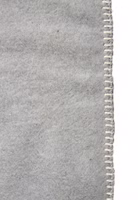 Nahaufnahme der Webkante einer hellgrauen Kuscheldecke mit dunkelgrauem Motive einer ausgestreckten Katze und dem Schriftzug Mach`s dir gemütlich