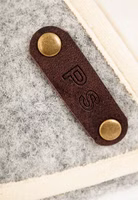 dunkelbraunes Leder Patch mit Initialien und dunkel goldenen Nieten