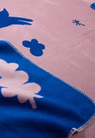eine rosa und dunkelblaue Kuscheldecke mit abstrakten Motiven von Blumen, Fahrrad, Katze, Mond 