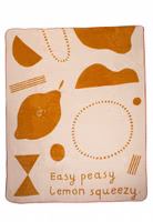 eine senfgelb- und beigefarbene Easy Peasy Kuscheldecke mit Zitronenmotiv und Schriftzug 