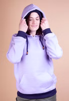 Adelheid Hoddie flieder eine Frau trägt einen lila Hoodie mit dunkelblauen Bündchen, Känguru-Tasche und zieht Kapuze über den Kopf