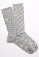 ein Paar hellgraue Glücksbringer Socken mit weißen Punkten, uni grau abgesetztem Bündchen-, Fersen- und Zehenbereich sowie oberhalb des Knöchels dem Motiv einer Edelweiß Blüte und dem Schriftzug Glücksbringer