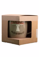 in einer Verpackung mit Sichtfenster seitlich eine taupe-grün farbende Henkeltasse aus Porzellan mit dem dunkelbraunen Schriftzug Glückspilz und darüber ein Fliegenpilz mit pastellorangem Hut