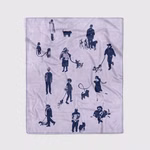 eine helllila-farbene Kuscheldecke mit dem dunkelblauen Motiv von verschiedenen Hundebesitzern mit deren Hunden zum Teil an der Leine