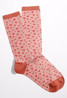 ein Paar rosa Zuckersüss Socken mit Herz-Allover in korallrot sowie abgesetzte Bündchen, Fersen- und Zehenbereiche in korallrot