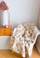 Adelheid Leo Kuscheldecke eine Adelheid Kuscheldecke mit Leopardenmuster auf einem Schaukelstuhl
