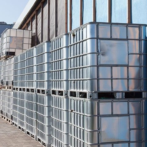 Gestapelte 1.000-Liter-IBC vor der Halle