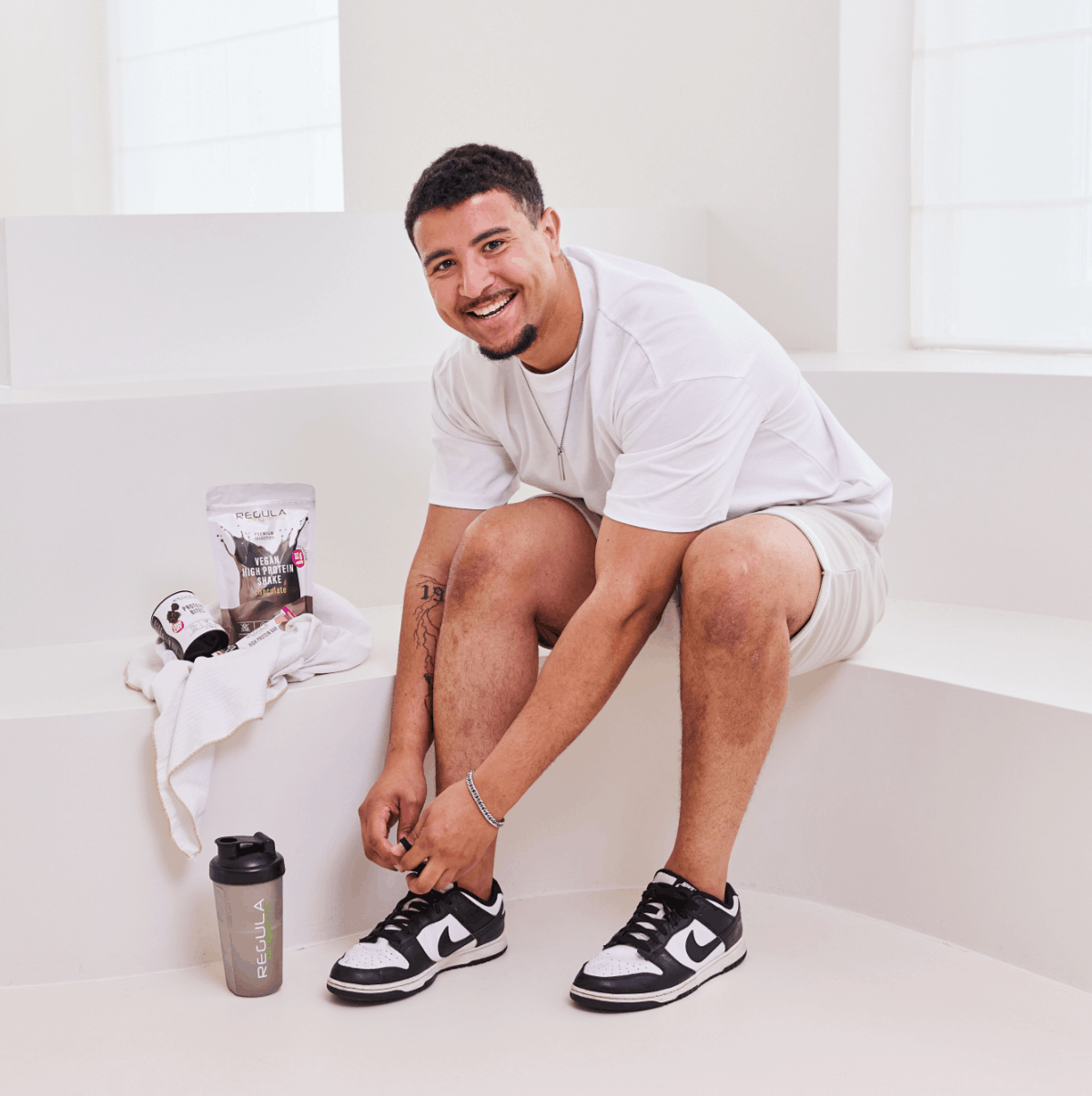 Mann bindet sich die Schuhe zu, sportlich gekleidet