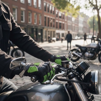 Close-up of leather and mesh motorcycle gloves on a rider's hands as he holds the handlebars of a motorcycle outdoors