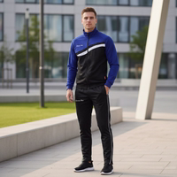 Model standing on sports field wearing STRIKER purple/black track suit with "German Wear" text. White stripe on chest and pants.