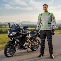 Cordura-Textil-Motorradjacken Herren steht auf der Straße, trägt Motorradjacke mit Protektoren. Motorräder im Hintergrund sichtbar.
