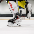 BAUER Vapor FLY40 Senior Eishockey-Schlittschuhe bei einem dynamischen Schritt auf dem Eis
