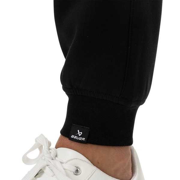 BAUER FLC Core Knit Jogger Senior in black, detail view of the ribbed ankle cuff with BAUER logo