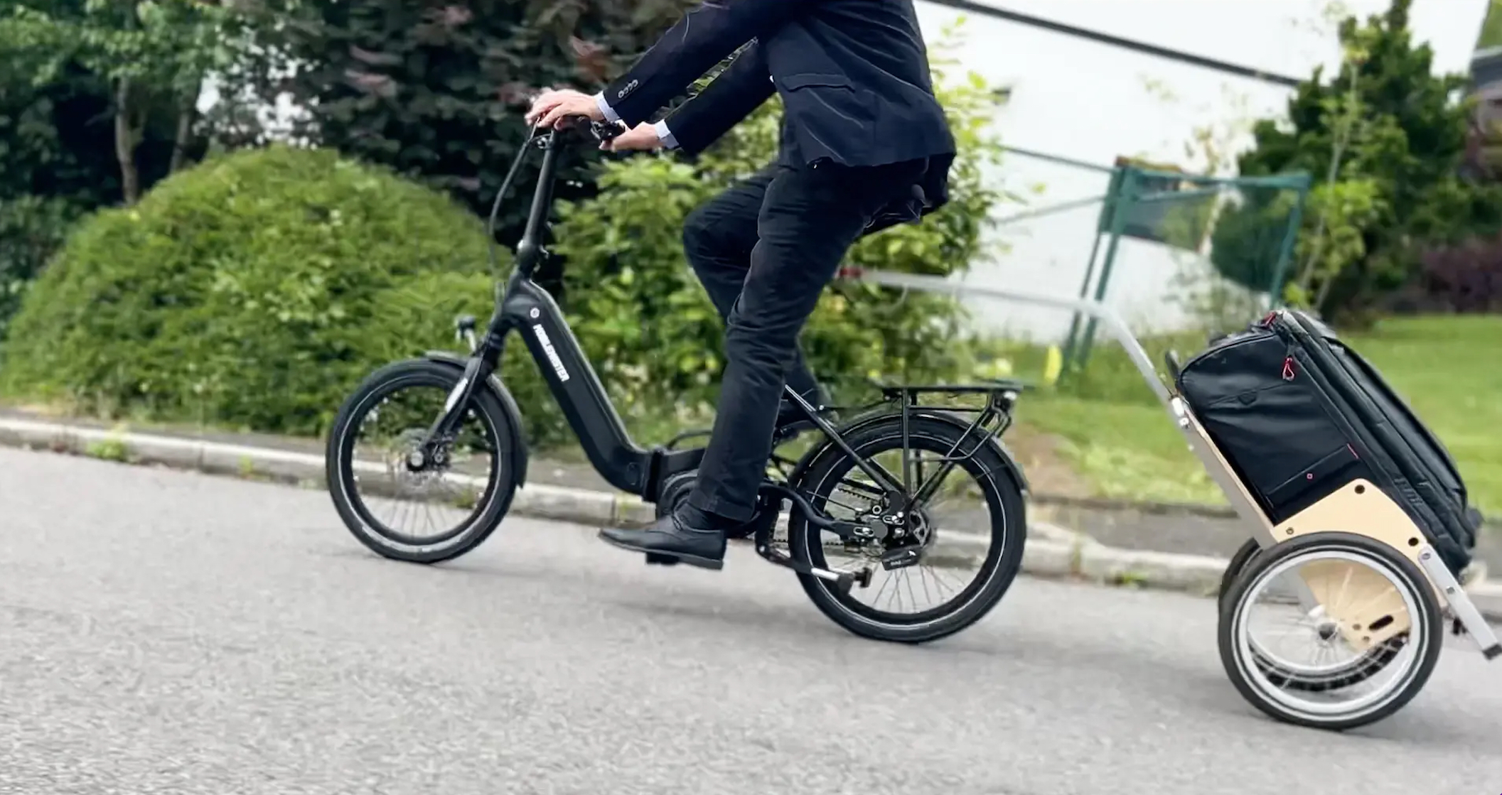 Geschäftsmann nutzt das Mobilemaster Rohloff E-14R PT CX SM E-Faltrad mit Bosch CX Smart System im extremen Hängerbetrieb an einer Steigung