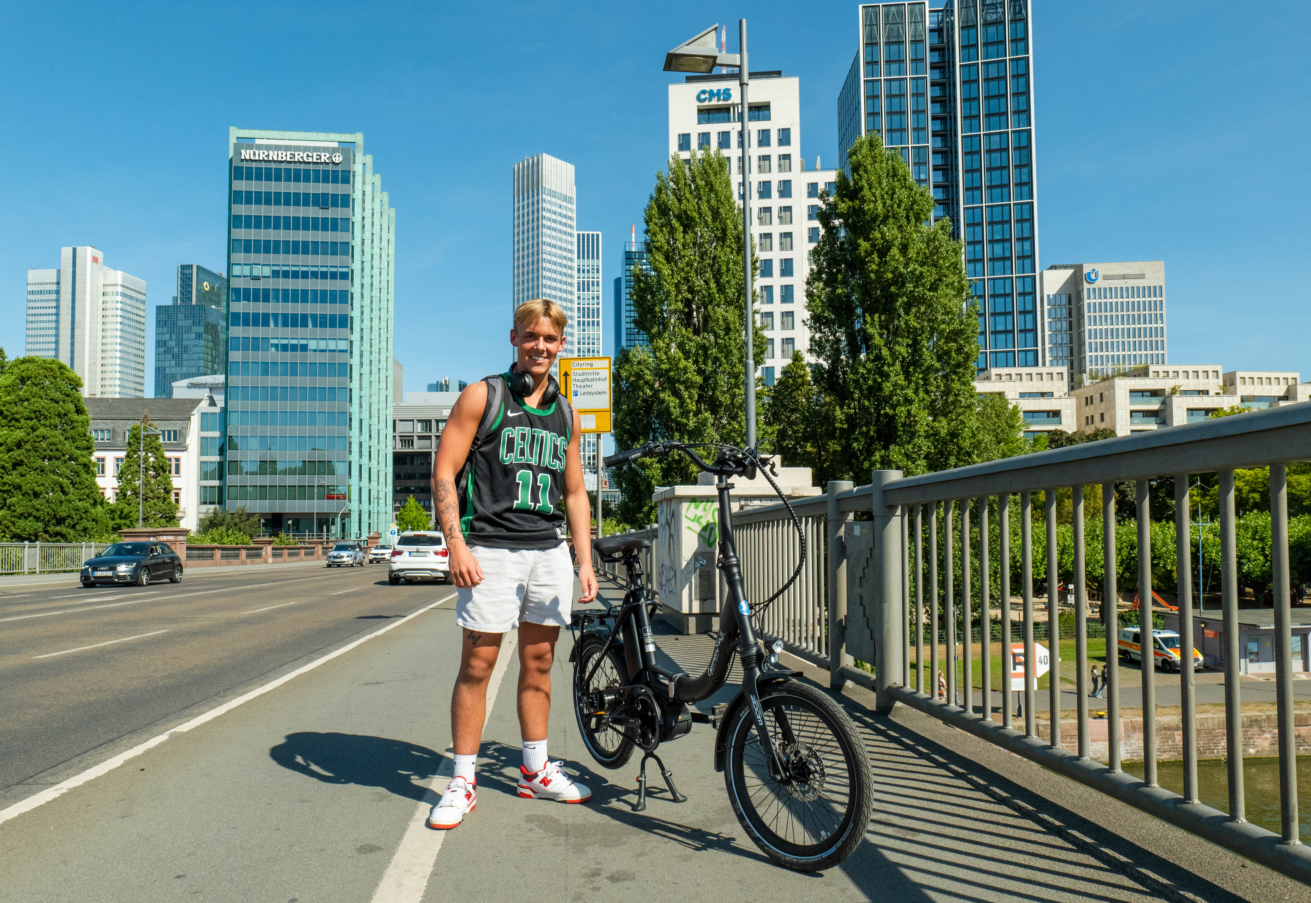 Sportlicher Pendler mit Mobilemaster Elektro-Klapprad Rohloff E-14 und Bosch Mittelmotor unterwegs im Stadtverkehr von Frankfurt
