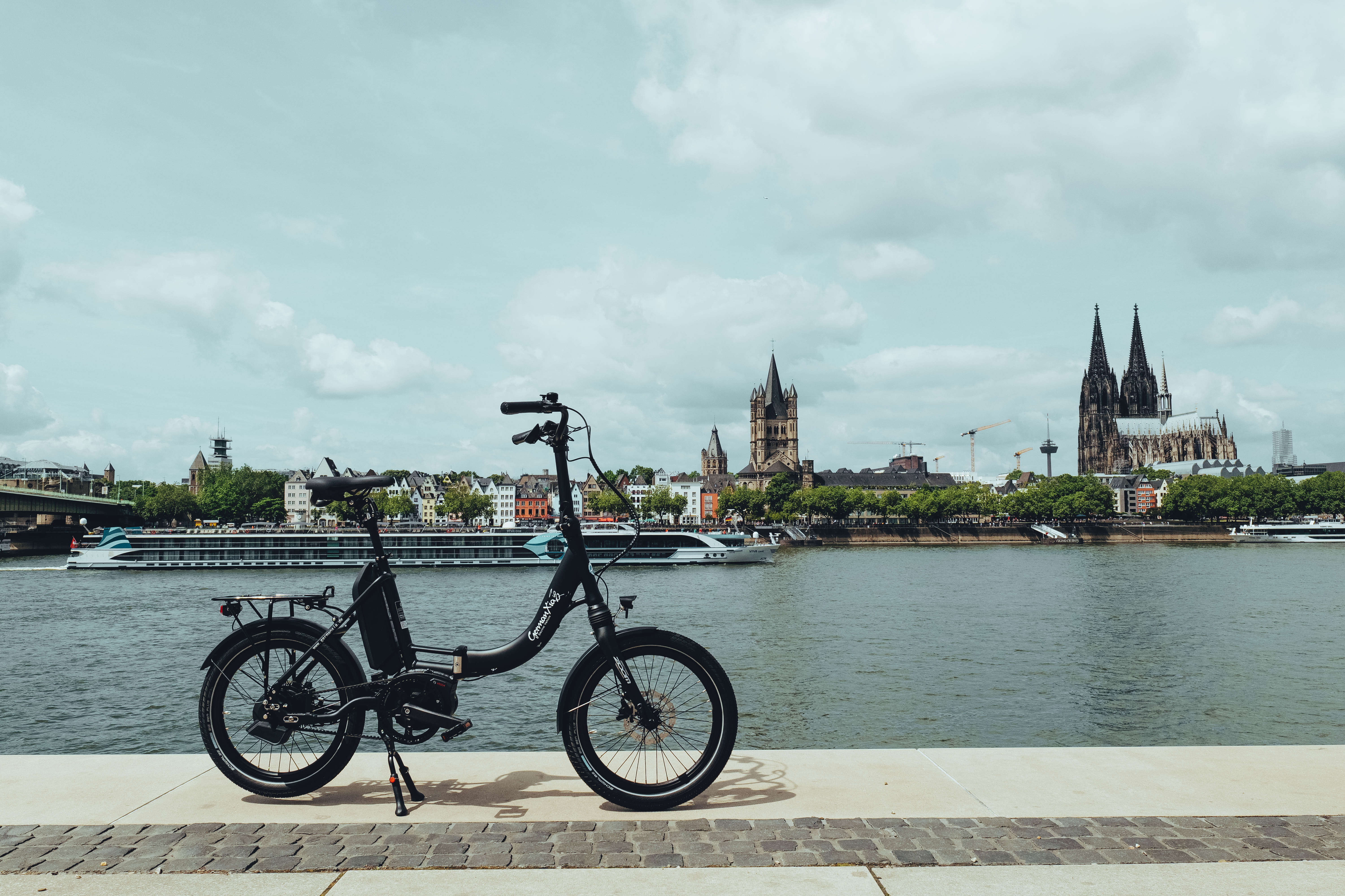 Kompaktes Mobilemaster PP E-Klapprad mit Rohloff E-14 und Bosch Motor am Rheinufer vor dem Kölner Dom