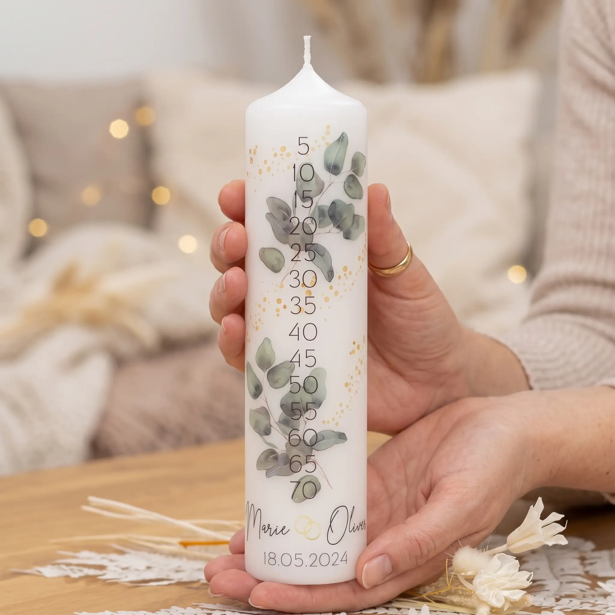 Jubiläumskerze mit Eukalyptus-Zweig, goldenen Punkten und Jahreszahlen-Skala von 5 bis 70, personalisiert mit Namen und Datum
